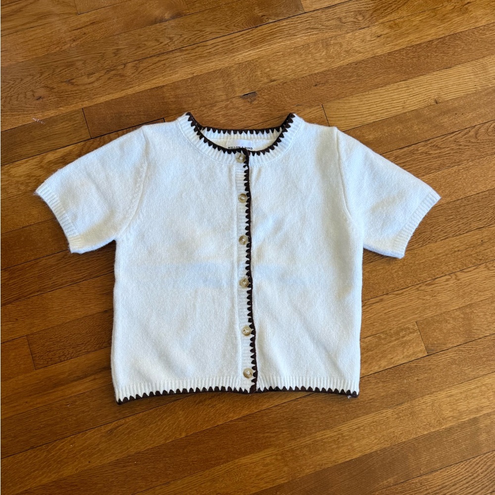 Willow and wind cropped cream sweaterer with brown trim.